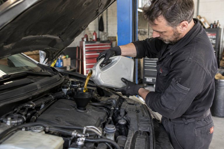 Un garagiste qui effectue une vidange d'un véhicule